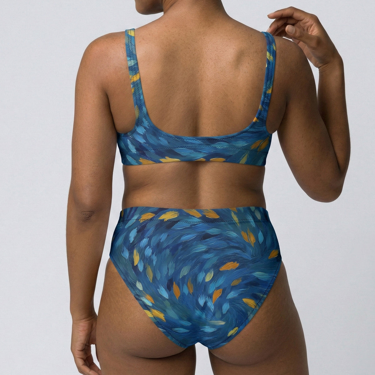 Person wearing a blue and yellow patterned bikini against a plain background