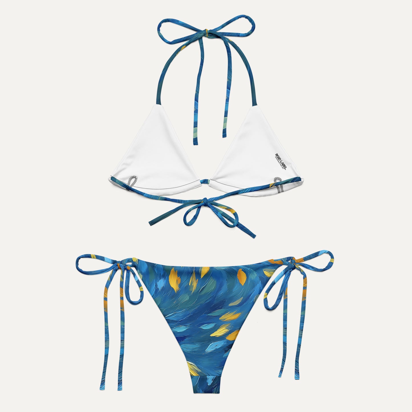 Bikini set with white top and blue and yellow patterned bottom on a white background