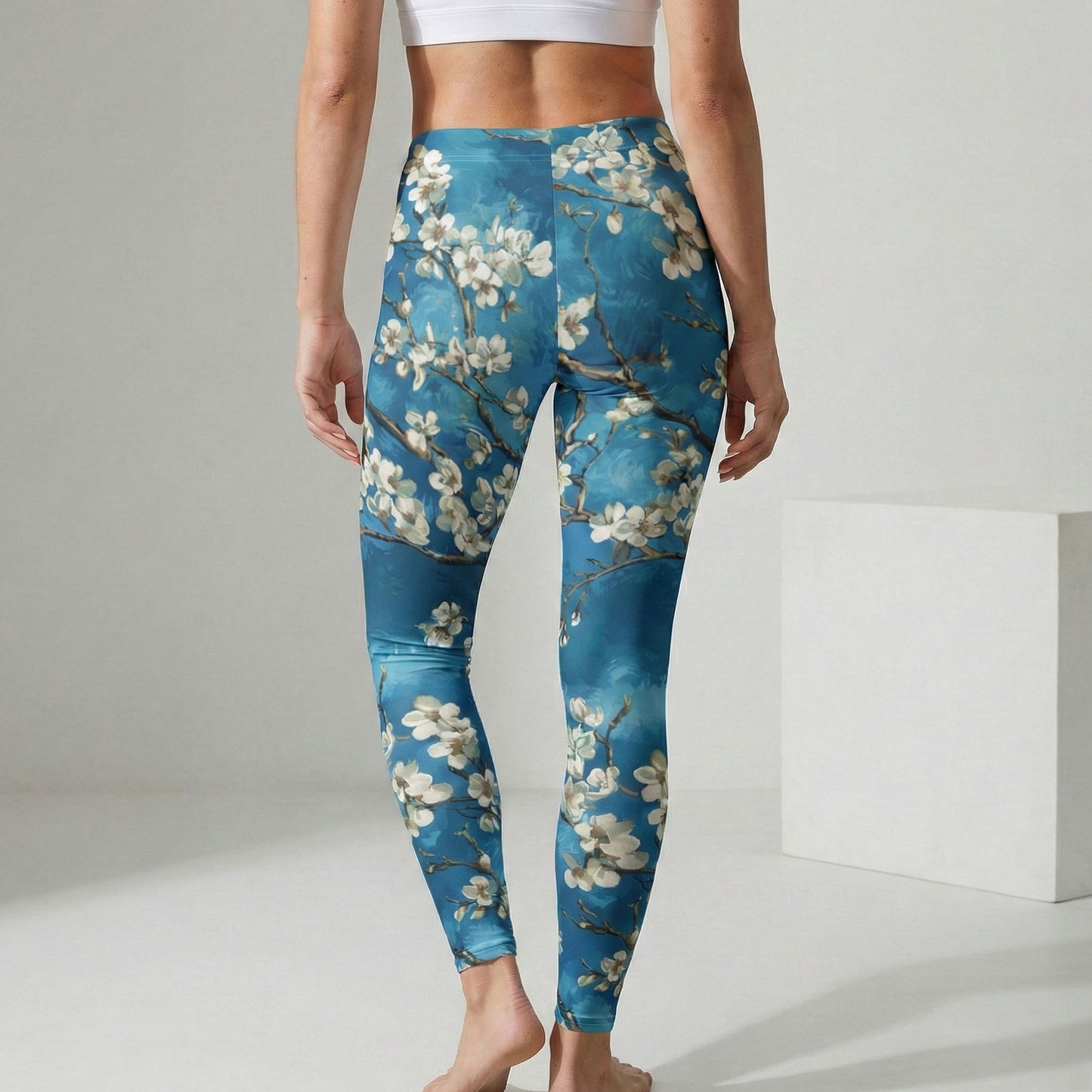 Person wearing blue floral leggings on a plain background