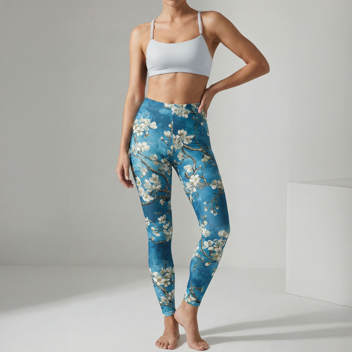 Person wearing blue floral leggings and white sports bra on a gray background