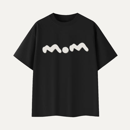 Black t-shirt with 'mom' printed in white on a light gray background