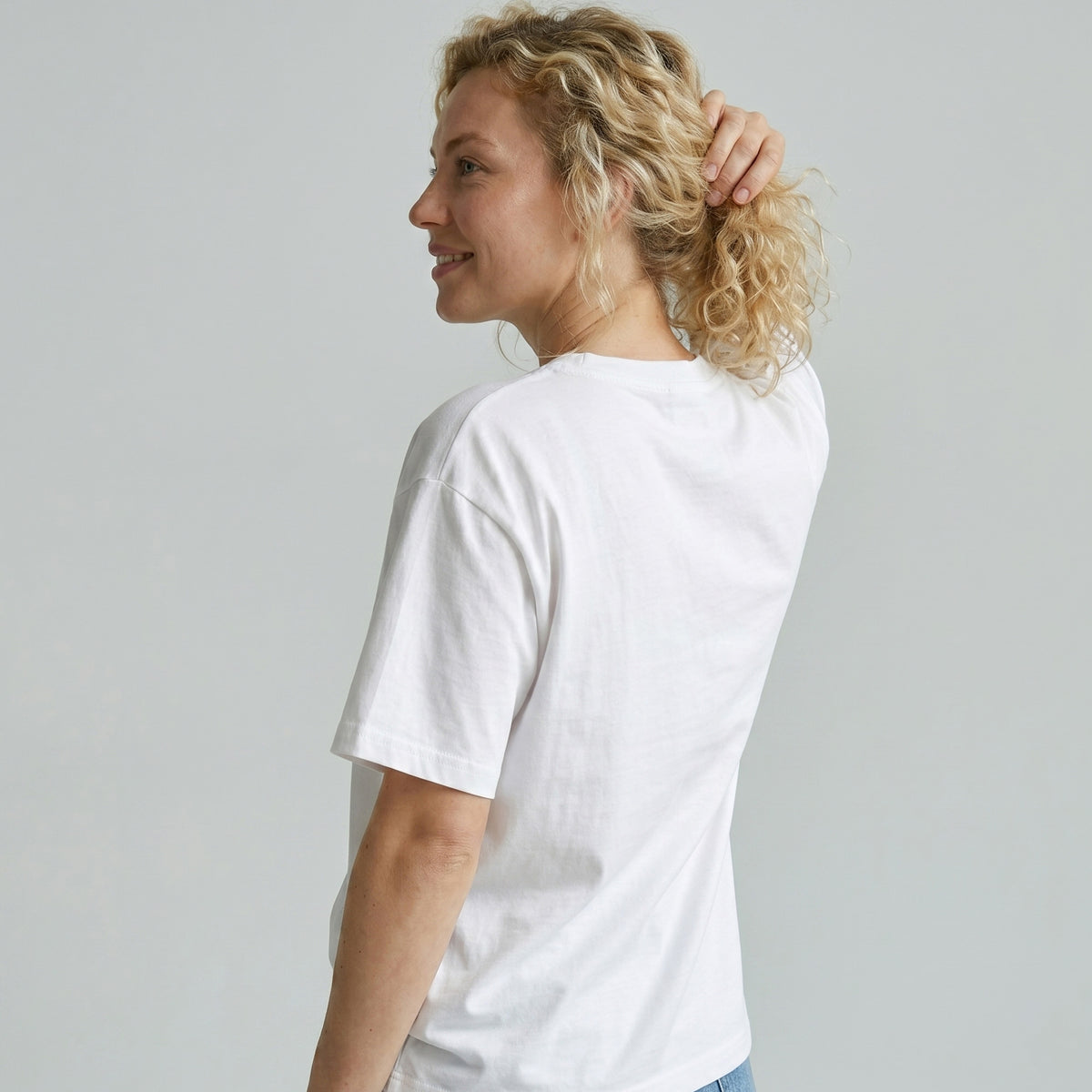 Woman wearing a plain white t-shirt against a light gray background