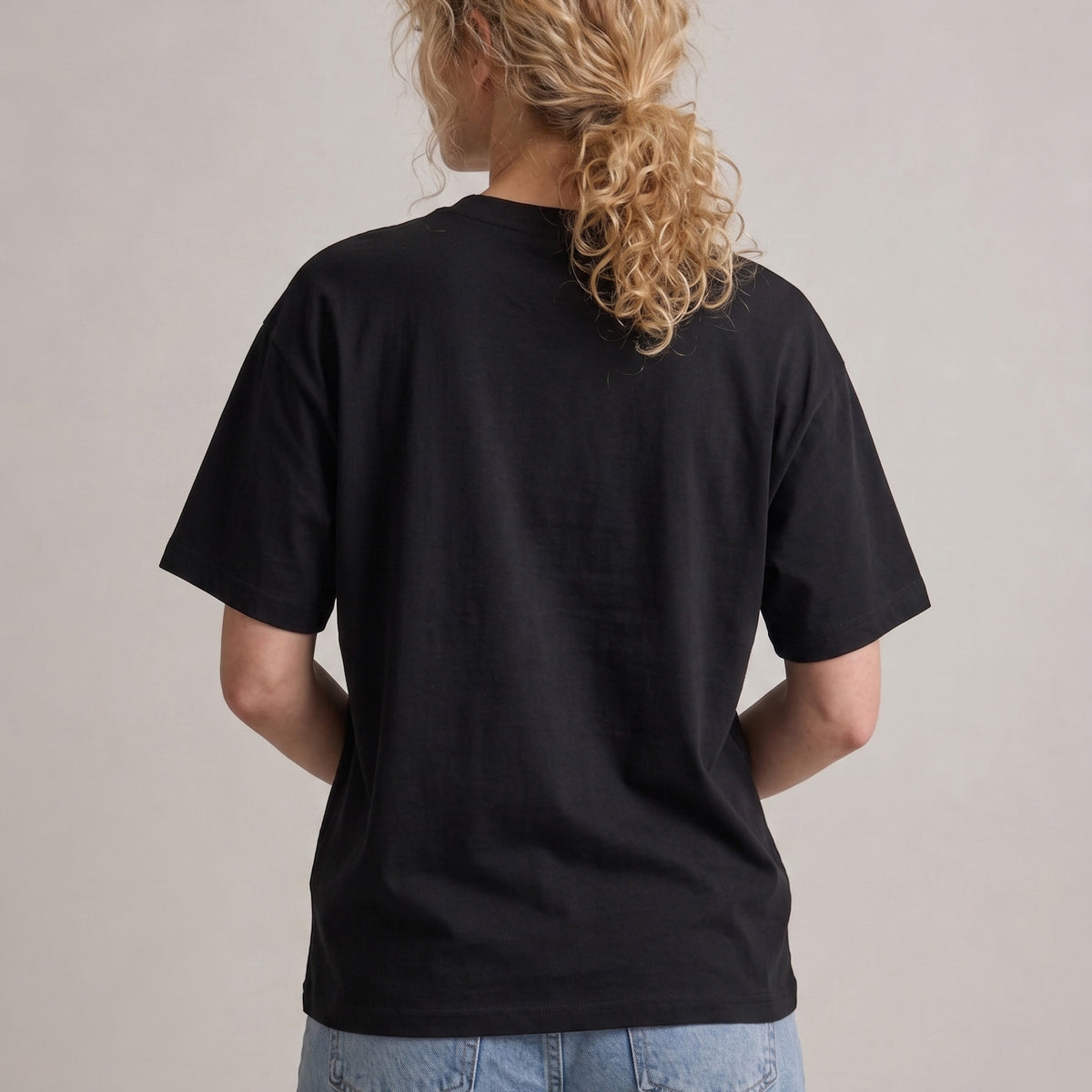 Person wearing a black t-shirt with a plain background
