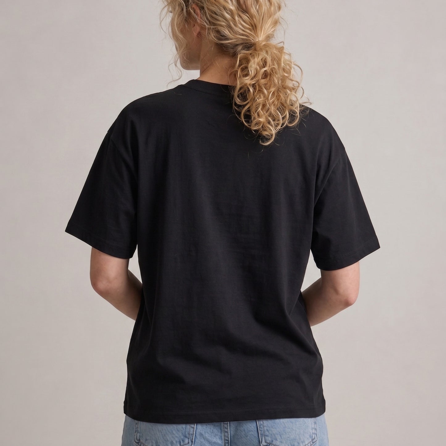 Person wearing a black t-shirt with a plain background