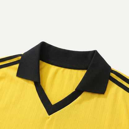 Yellow shirt with black collar and stripes on a light gray background
