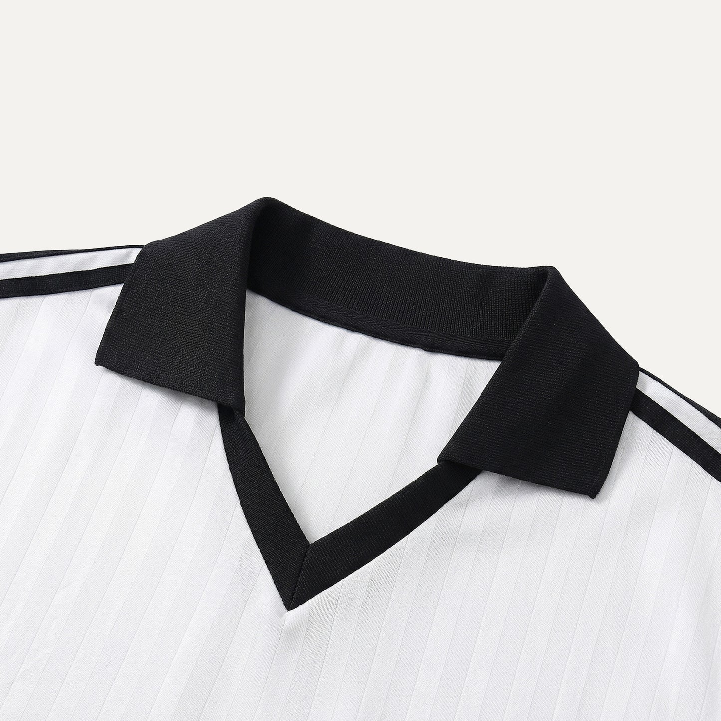 Close-up of a white shirt with black collar and stripes on a light gray background