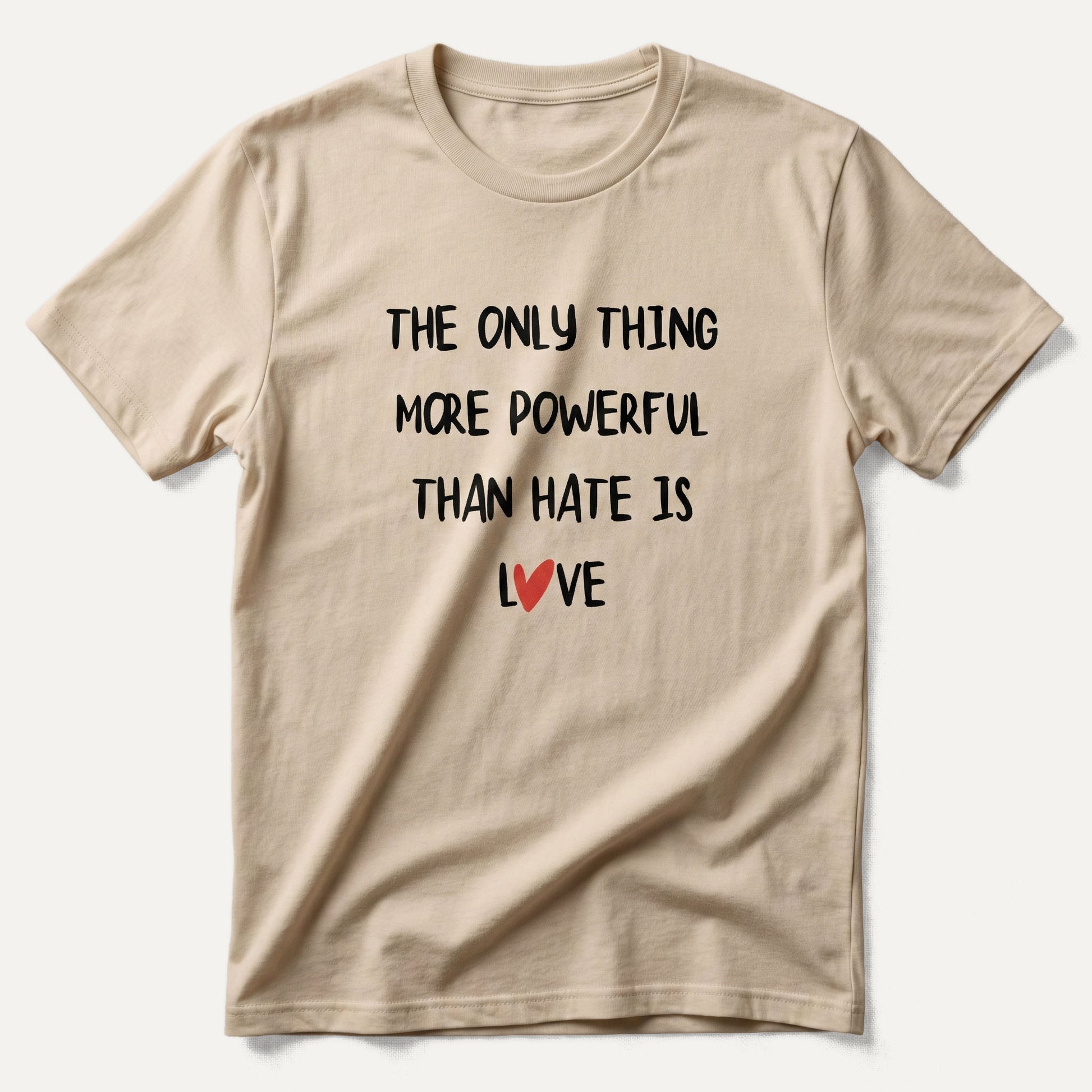 Beige t-shirt with motivational quote 'The only thing more powerful than hate is love' on a white background