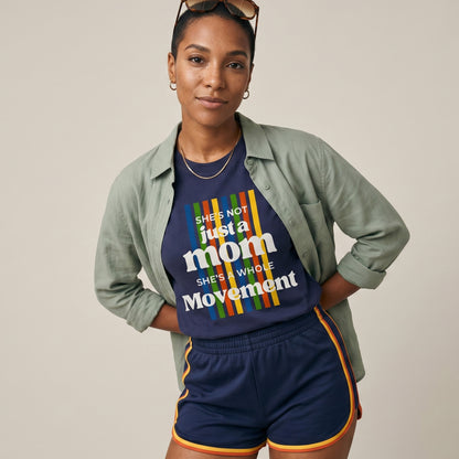 Woman wearing a navy blue t-shirt with colorful text and green jacket on a beige background