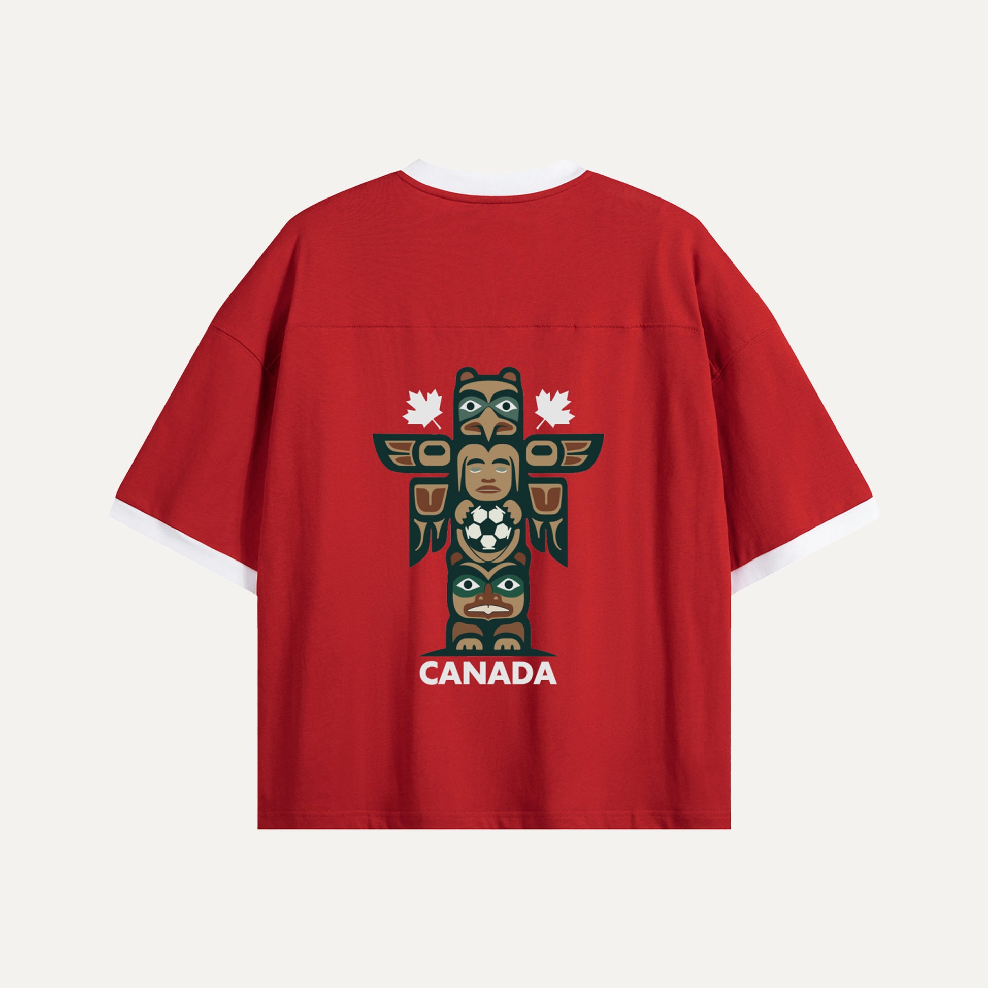 Flat lay of the back of a red Gallery of Nations jersey featuring a detailed totem pole graphic holding a soccer ball, flanked by two white maple leaves.