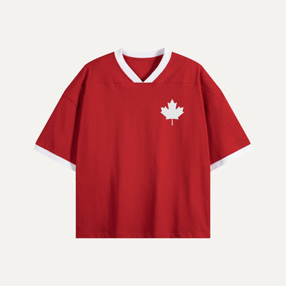 Front view of the Bold Label "Gallery of Nations" Canada jersey, featuring a red body with a white V-neck, white sleeve cuffs, and a minimalist white maple leaf logo on the left chest.