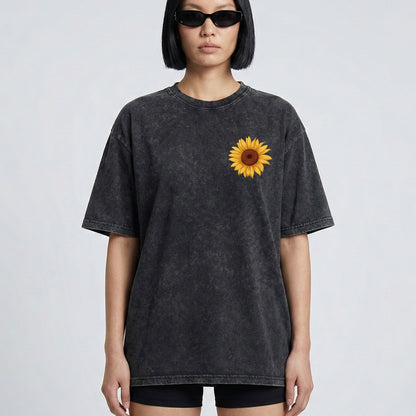 Person wearing a black t-shirt with a sunflower design on a plain background