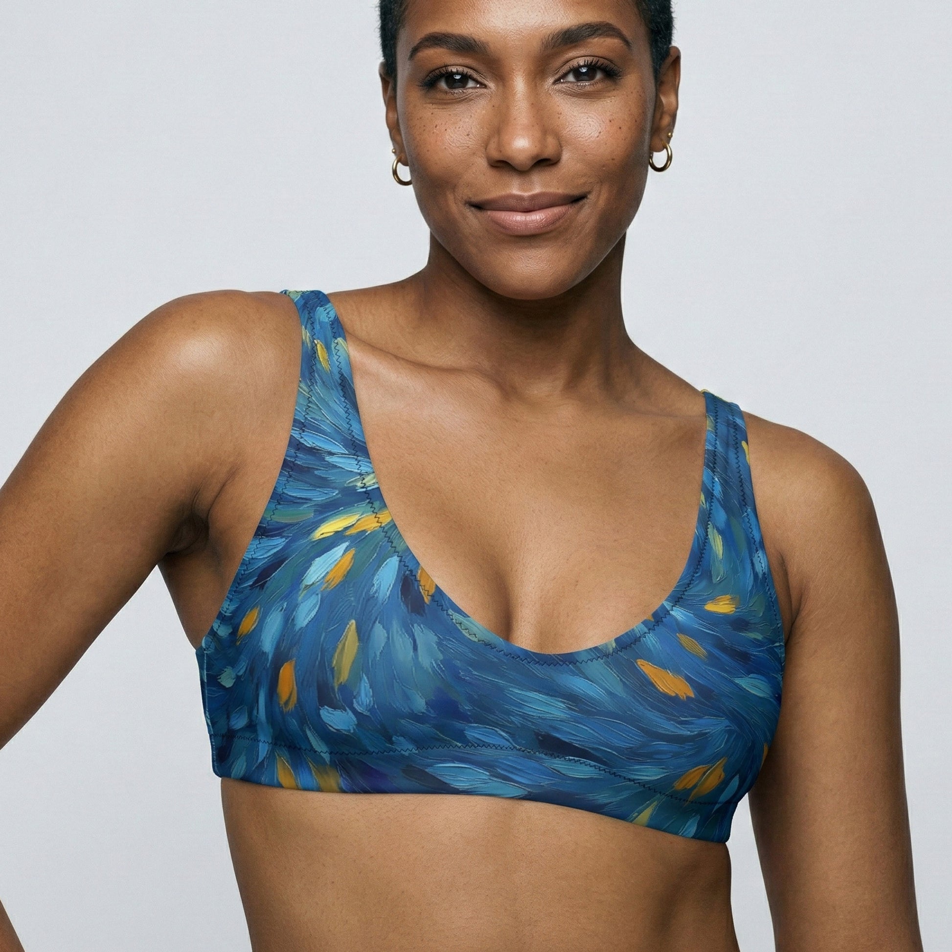 Woman wearing a blue patterned sports bra against a plain background