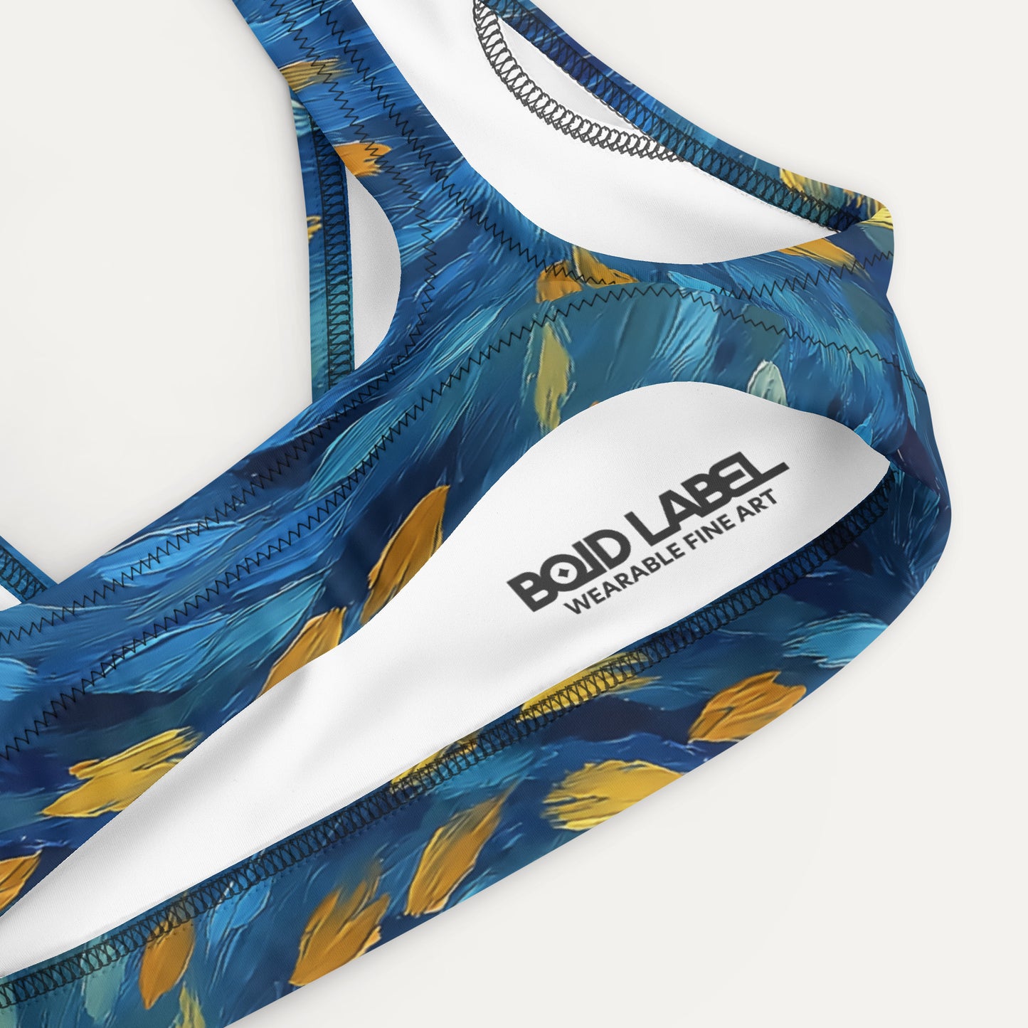Blue and yellow patterned bikini top with 'Bold Label' branding on a white background