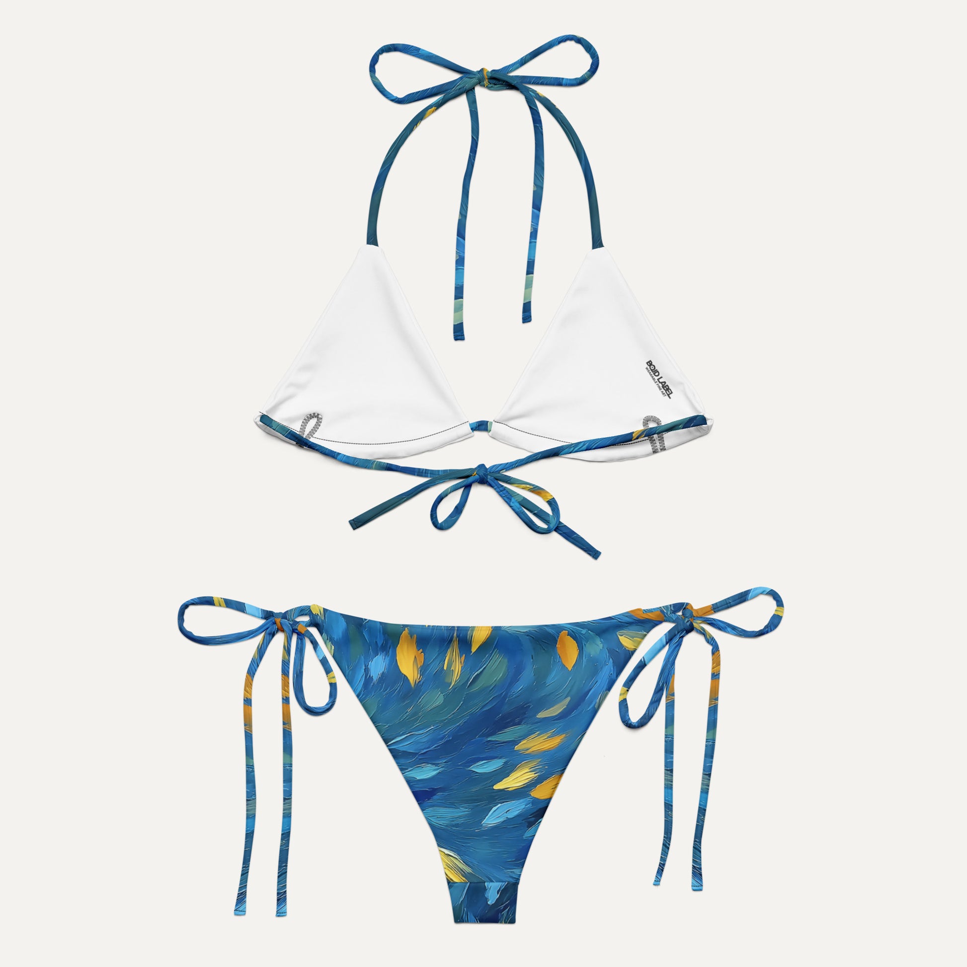 Bikini set with white top and blue and yellow patterned bottom on a white background