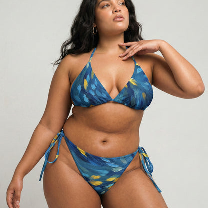 Woman wearing a blue patterned bikini against a plain background