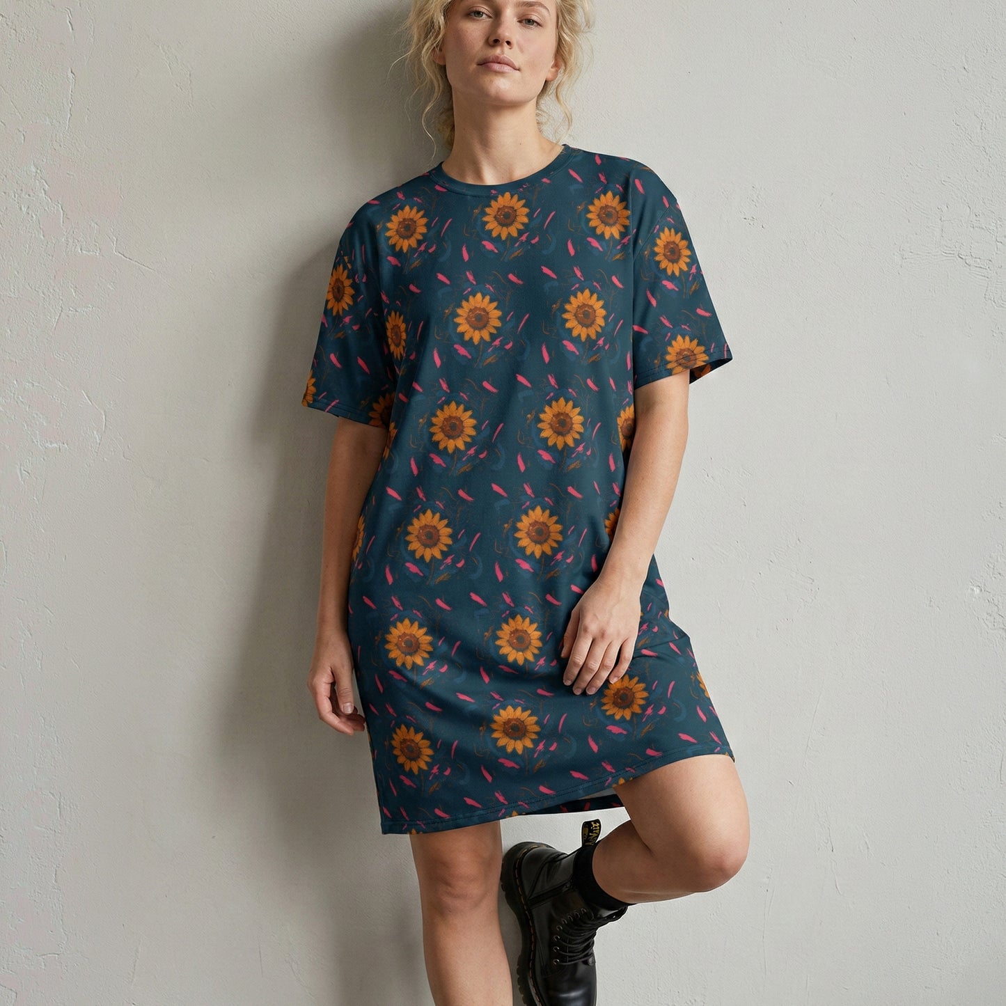 Woman wearing a blue dress with sunflower pattern against a plain background