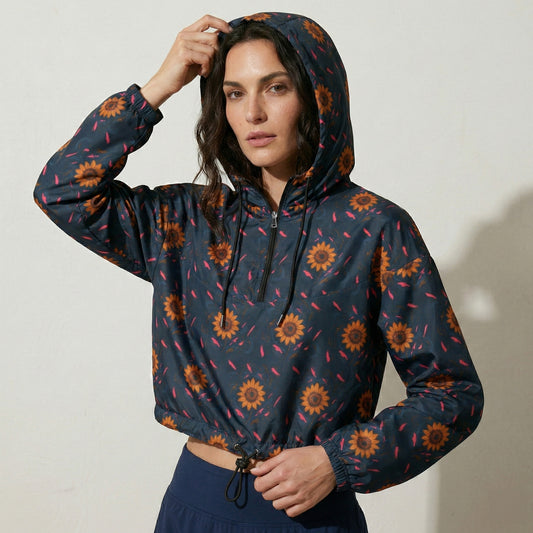 Woman wearing a dark blue jacket with sunflower pattern against a plain background