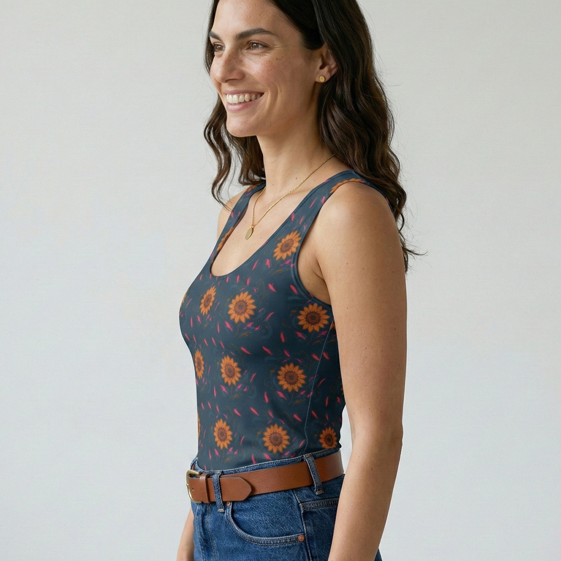 Woman wearing a patterned tank top and jeans against a plain background