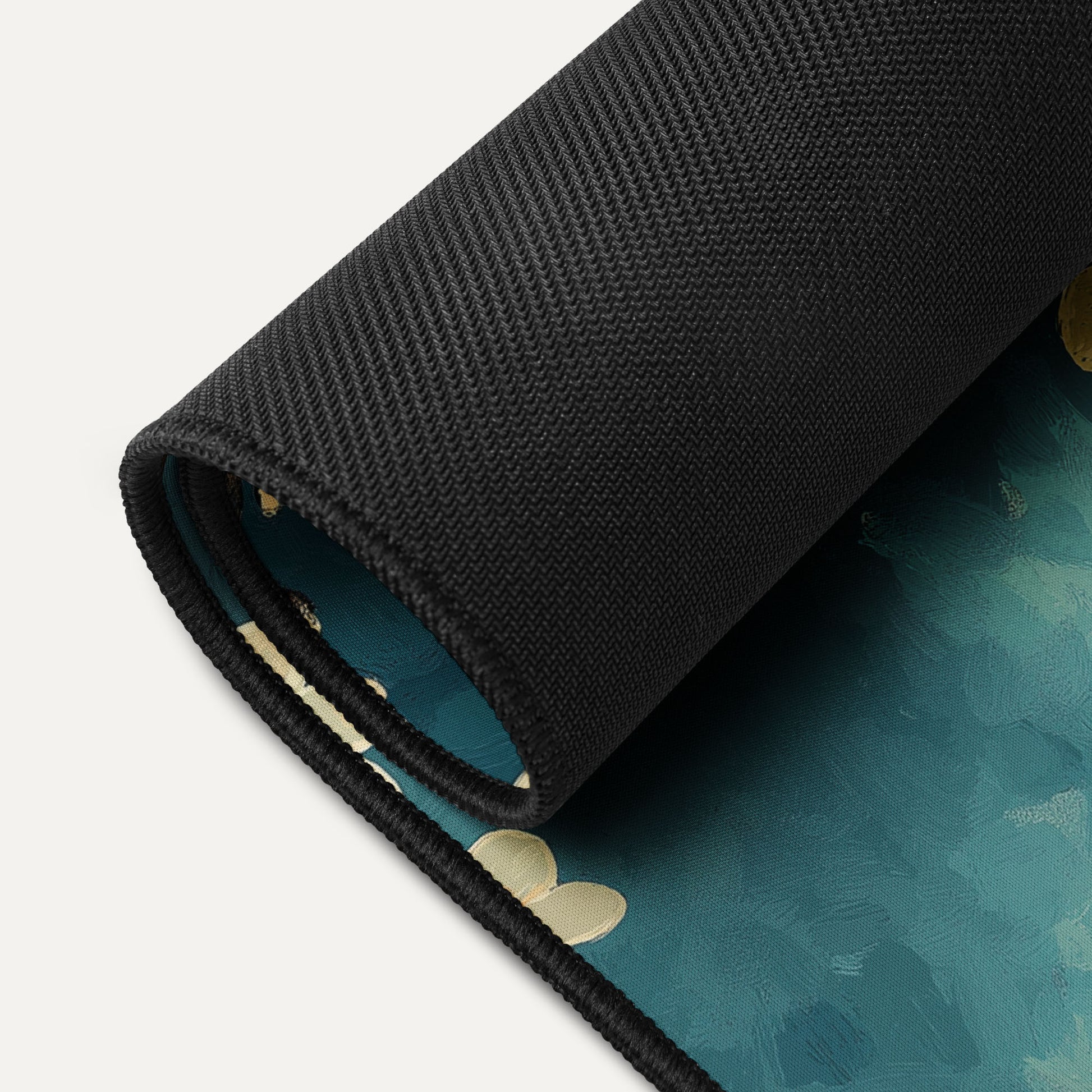 Close-up of a folded desk mat on a teal surface with gold accents