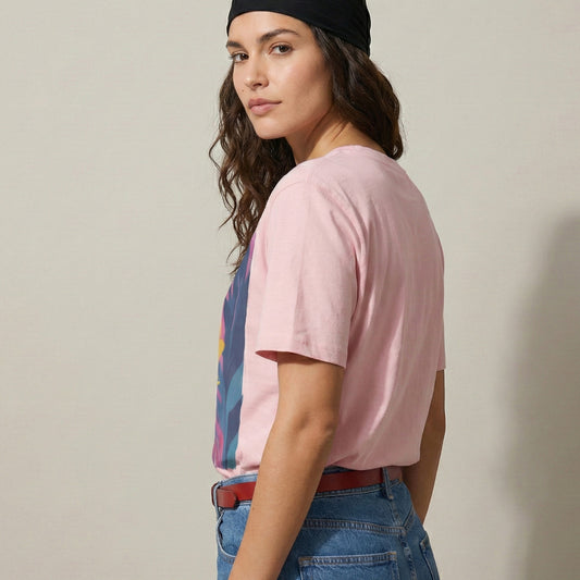 Woman wearing a pink t-shirt with a colorful graphic, blue jeans, and a black headband against a beige background.