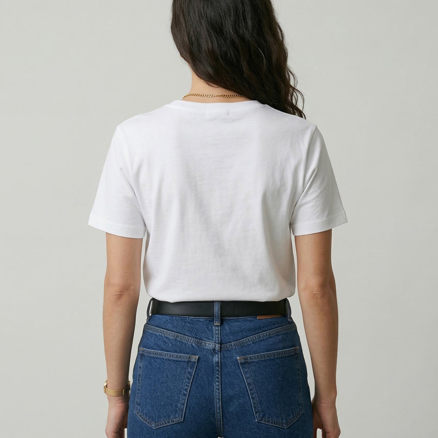 Person wearing a white t-shirt and blue jeans from behind on a plain background
